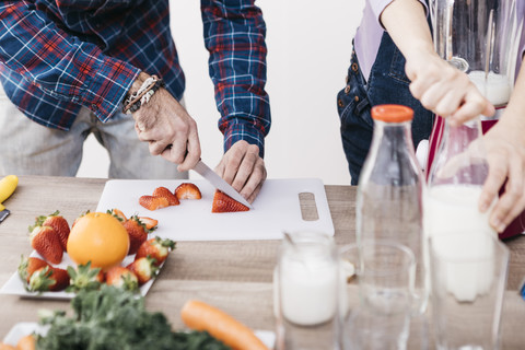 Ehepaar bereitet Smoothies mit frischem Obst und Gemüse zu, Teilansicht, lizenzfreies Stockfoto