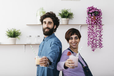 Porträt eines Paares mit Gläsern mit verschiedenen Smoothies zum Trinken - JRFF01240