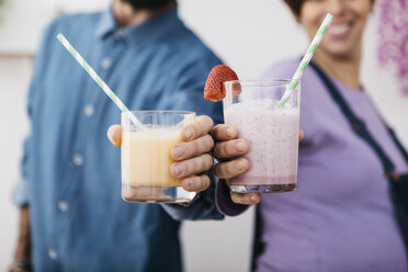 Pärchen mit Gläsern mit verschiedenen Smoothies, die zum Trinken bereitstehen, Teilansicht - JRFF01241