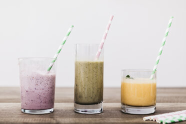 Three glasses of various smoothies in a row - JRFF01242