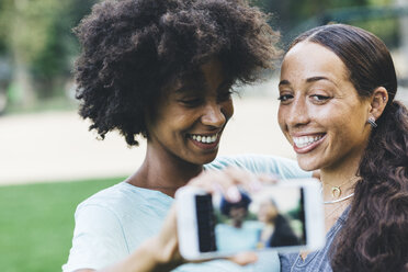 Portrait of two best friends taking selfie in a park - GIOF01984