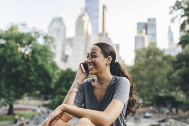 USA, Manhattan, Porträt einer jungen Frau beim Telefonieren im Central Park - GIOF02001