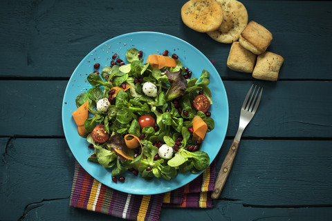 Teller mit Feldsalat, Möhren, Tomaten, Mozzarella und Granatapfelkernen, lizenzfreies Stockfoto