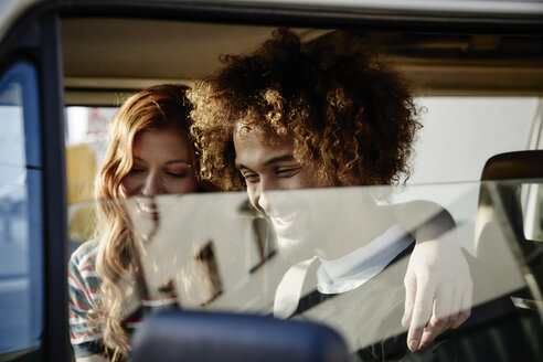 Glückliches junges Paar in einem Auto - FMKF03486