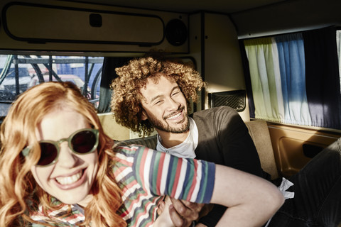 Glückliches junges Paar in einem Lieferwagen, lizenzfreies Stockfoto