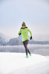 Deutschland, Bayern, Kochelsee, Frau joggt im Winter - MRF01689