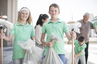 Eine Gruppe freiwilliger Kinder sammelt mit Abfallstöcken Müll ein - ZEF12889