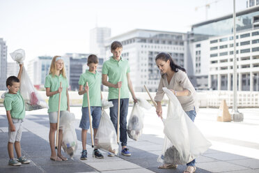 Eine Gruppe freiwilliger Kinder sammelt mit Abfallstöcken Müll ein - ZEF12894