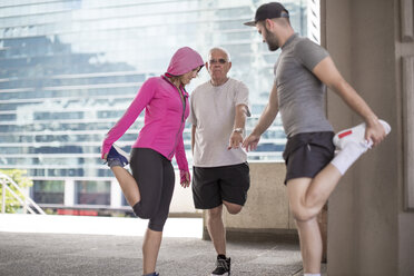 Three athletes stretching in the city - ZEF12941