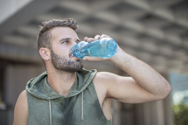 Sportler macht eine Pause in der Stadt und trinkt Wasser aus einer Flasche - ZEF12952