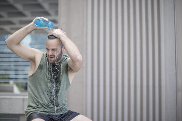 Athlete taking a break pouring water over his head - ZEF12954