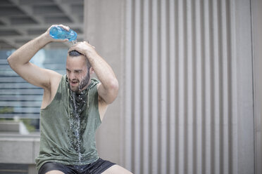 Sportler macht eine Pause und gießt sich Wasser über den Kopf - ZEF12954