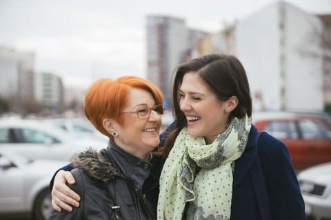 Glückliche erwachsene Tochter mit Mutter in der Stadt, lizenzfreies Stockfoto