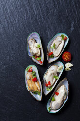 Green mussels with tomatoes, capsicum and garlic, on black slate slab - CSF27945