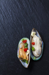 Green mussels with tomatoes, capsicum and garlic, on black slate slab - CSF27948