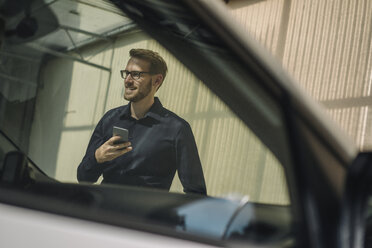 Lächelnder Geschäftsmann mit Mobiltelefon - KNSF01061