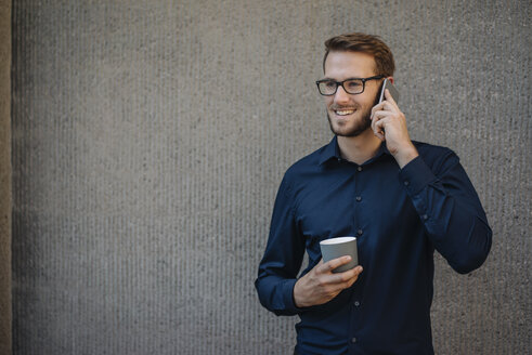 Lächelnder Geschäftsmann, der mit seinem Handy telefoniert - KNSF01065