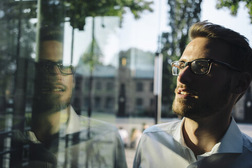 Businessman looking out of window - KNSF01080