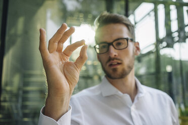 Businessman holding small star in his hand - KNSF01081