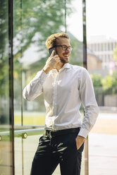 Smiling businessman talking on cell phone - KNSF01104