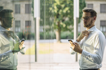 Businessman looking on cell phone - KNSF01109