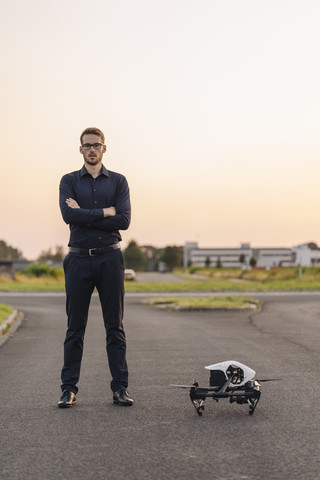 Geschäftsmann steht neben einer Drohne, lizenzfreies Stockfoto