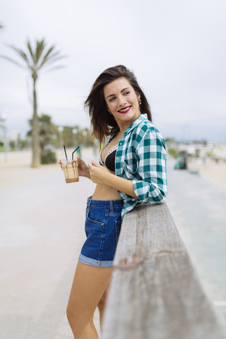 Young woman at the beach with cup of coffee stock photo