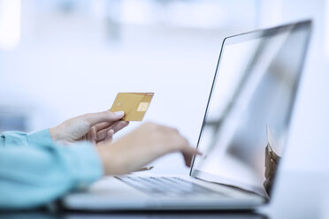 Frau hält Kreditkarte und tippt auf Computer, um eine Online-Zahlung zu tätigen - ZEF12980