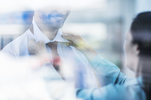 Woman helping a man with his tie stock photo