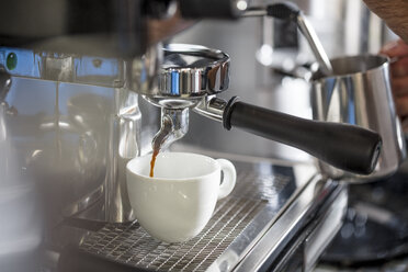Kaffee aus der Espressomaschine fließt in die Tasse - ZEF12995
