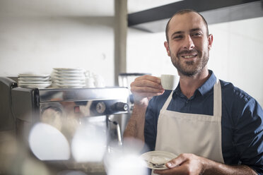 Porträt eines lächelnden Barista, der Espresso trinkt - ZEF13003