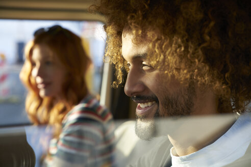 Lächelnder junger Mann mit Freundin in einem Auto - FMKF03490