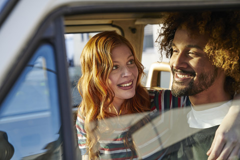 Smiling young woman looking at boyfriend in a car stock photo