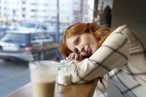 Daydreaming young woman in a cafe stock photo