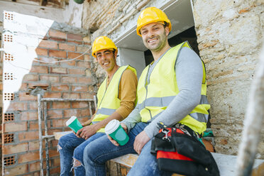 Construction workers having a coffee break on construction site - KIJF01246