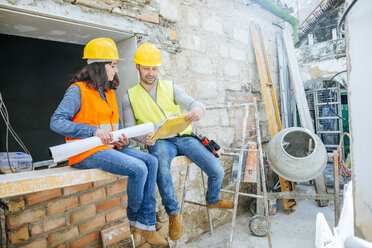 Männlicher und weiblicher Bauarbeiter im Gespräch auf der Baustelle - KIJF01248