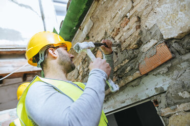 Bauarbeiter bei der Arbeit mit Hammer und Meißel - KIJF01250