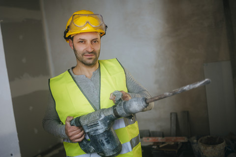 Porträt eines Bauarbeiters, der einen Presslufthammer hält, lizenzfreies Stockfoto