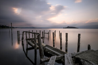 Italien, zerstörter alter Steg am See bei Sonnenuntergang - SIPF01422