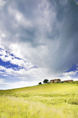 Italien, bewölkter Himmel über Häusern auf einem Hügel, lizenzfreies Stockfoto