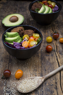 Lunch bowls of leaf salad, red cabbage, avocado, tomatoes and quinoa fritters - LVF05896