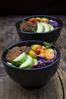 Mittagsschüsseln mit Blattsalat, Rotkohl, Avocado, Tomaten und Quinoa-Fritters - LVF05899