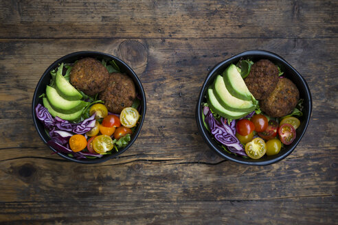 Lunch bowls of leaf salad, red cabbage, avocado, tomatoes and quinoa fritters - LVF05900