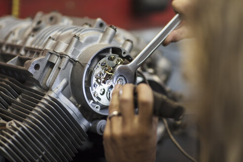 Mechaniker bei Arbeiten am Motorradmotor in der Werkstatt - ZEF13016