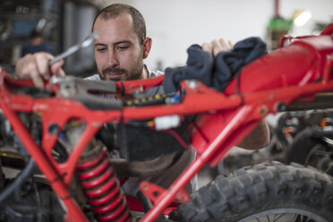 Mechanic working on motorcycle in workshop - ZEF13023