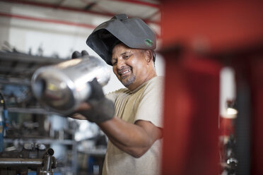 Mechaniker in der Werkstatt mit Motorradauspuff - ZEF13032