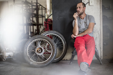 Mechaniker in der Werkstatt raucht eine Zigarette - ZEF13033