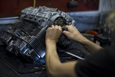 Mechaniker bei Arbeiten am Motorradmotor in der Werkstatt - ZEF13037