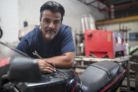 Porträt eines selbstbewussten Mechanikers in einer Motorradwerkstatt, lizenzfreies Stockfoto