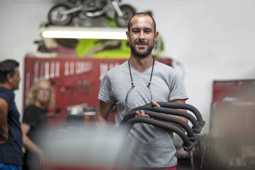 Portrait of smiling mechanic in motorcycle workshop - ZEF13055